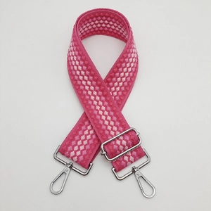 Dettaglio della tracolla in tela regolabile con motivo rosa e ganci in metallo argento