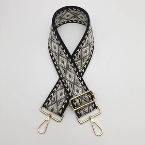 Close-up of geometric diamond pattern strap with polished gold metal hardware