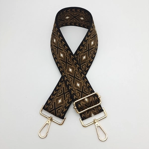 Close-up of adjustable diamond pattern woven bag strap with golden metal lobster clasps
