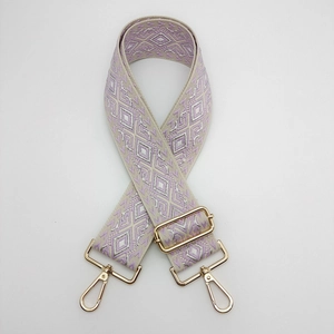 Detail of adjustable geometric diamond pattern nylon strap with gold metal hardware