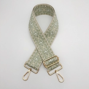 Close-up of adjustable green diamond pattern nylon strap with gold metal hardware