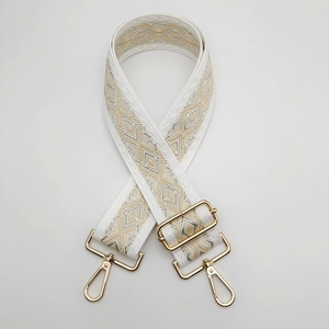 Detail of adjustable geometric diamond pattern wide nylon shoulder strap with gold lobster clasps