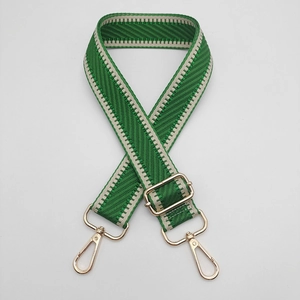 Détail de la bandoulière réglable à chevrons vert et beige avec mousquetons dorés