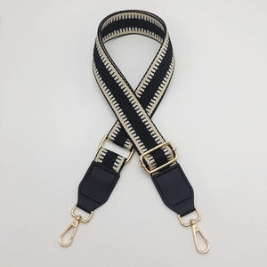 Macro shot of chevron pattern woven strap with gold metal hooks and black leather ends
