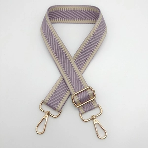 Détail de la bandoulière tissée géométrique violette et beige avec mousquetons dorés