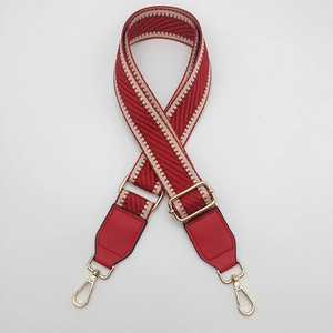 Detail of red chevron woven bag strap with gold metal lobster clasp and adjuster