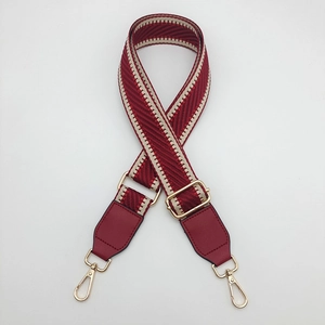 Macro detail of red herringbone woven strap with high-quality gold metal lobster clasps