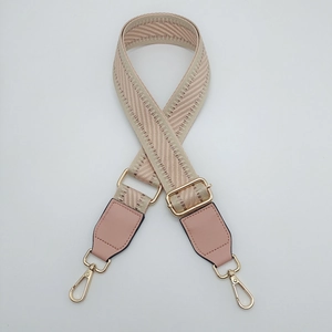 Detail of pink herringbone woven strap with golden metal swivel hooks and buckles
