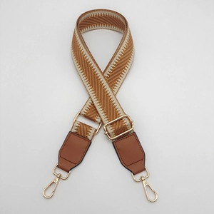 Adjustable brown and beige woven canvas shoulder strap with gold metal hooks for handbags