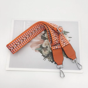 Close-up of woven ethnic pattern phone strap with silver metal swivel hooks and leather ends