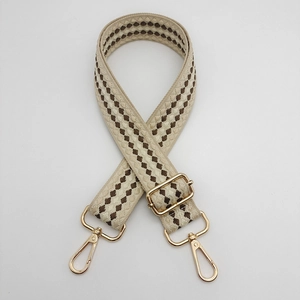 Adjustable wide woven shoulder strap with beige and brown geometric patterns and gold buckles