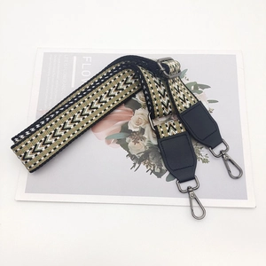 Close-up of geometric pattern crossbody strap with dark metal swivel hooks and leather ends