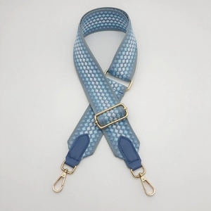 Detail of adjustable blue and white lattice purse strap with gold metal lobster claws