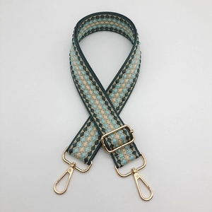 Detail of adjustable plaid shoulder strap with golden metal swivel hooks for bags