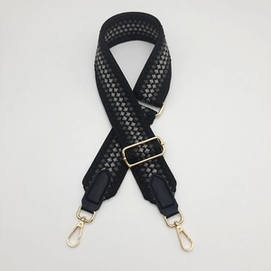 Detail of 5cm wide geometric woven strap with gold metal hooks and black leather