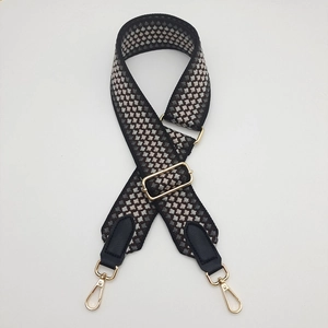 Close-up of adjustable geometric weave strap with gold metal buckles and leather ends