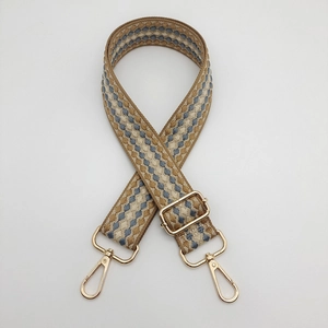 Close-up of woven bag strap with blue plaid pattern and golden metal swivel hooks