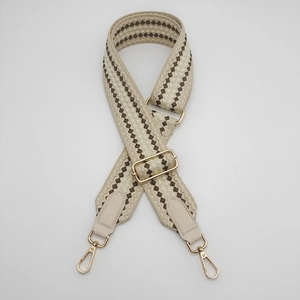 Close-up of adjustable woven bag strap with geometric dots and gold metal hardware
