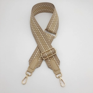 Detail of 5cm wide beige strap with gold geometric weave and metal lobster clasps
