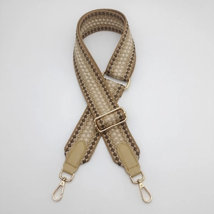 Detail of 5cm wide jacquard geometric strap with gold metal buckle and PU leather ends