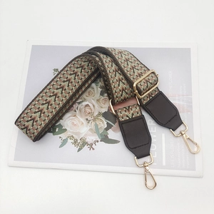 Close-up of adjustable jacquard bag strap with geometric patterns and gold metal hooks