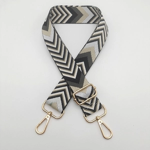 Close-up of 5cm wide jacquard strap with black and grey chevron pattern and gold hardware
