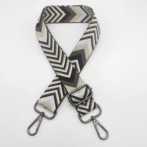 Close-up of thick adjustable wide bag strap with gray chevron pattern and gunmetal hardware