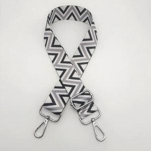 Close-up of black and white wave pattern wide nylon strap with silver metal lobster clasps