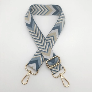Close-up of wide chevron patterned bag strap with gold rotating lobster clasps