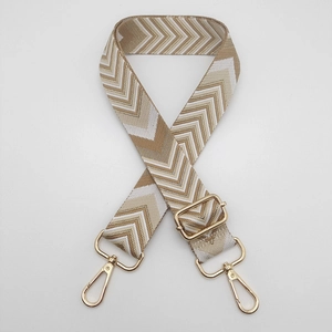 Detail view of thickened adjustable wide shoulder strap with beige wave pattern and gold hooks