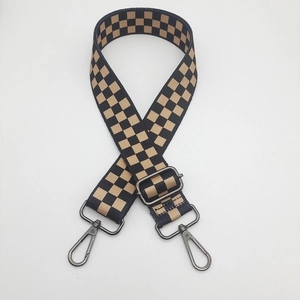 Close-up of adjustable wide nylon shoulder strap with checkered pattern and metal hooks