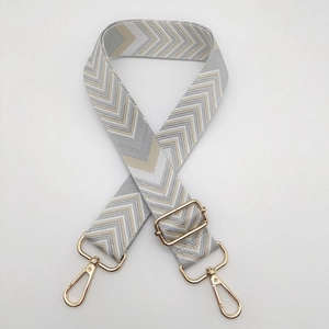 Detail of adjustable chevron strap with golden swivel hooks for crossbody handbags