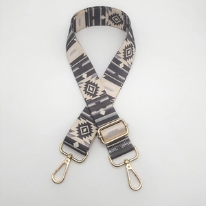 Detail of adjustable geometric ethnic strap with golden lobster clasps for bags