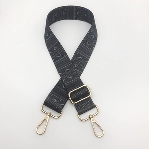Close-up of ethnic geometric jacquard guitar strap with light gold metal swivel hooks