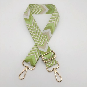 Detail view of woven green chevron shoulder strap with premium golden swivel hooks