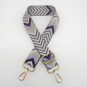 Close-up of thick woven shoulder strap with purple zigzag pattern and gold metal hardware