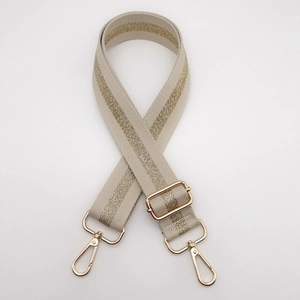 Close-up of adjustable beige strap with gold glitter stripe and shiny metal lobster hooks