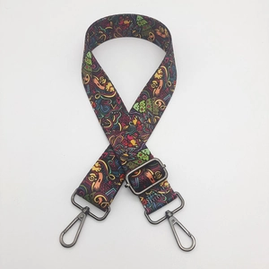 Detail of adjustable nylon strap with colorful graffiti print and gun-metal hardware