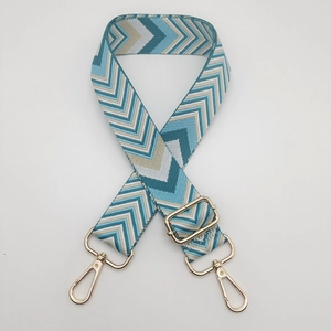 Close-up of blue and beige chevron woven wide strap with gold hardware hooks