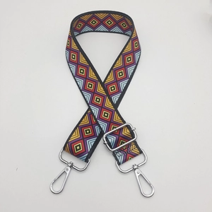 Close-up of colorful geometric nylon shoulder strap with silver lobster clasps and buckle
