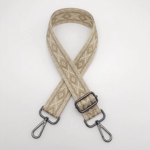 Close-up of adjustable woven shoulder strap with geometric patterns and metal hooks