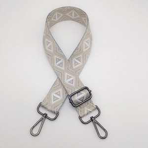 Macro detail of adjustable striped bag strap with diamond weave and grey metal hooks