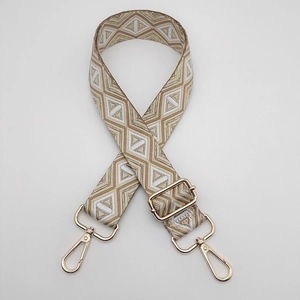 Macro detail of adjustable woven strap with ethnic pattern and golden metal hooks