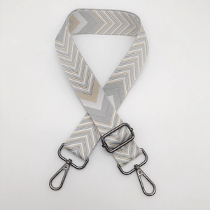 Detail of adjustable woven bag strap with chevron pattern and gunmetal swivel hooks
