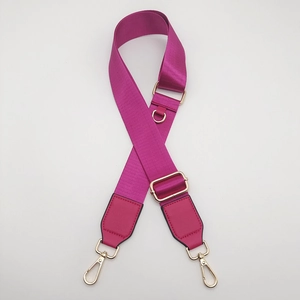 Close-up of fuchsia nylon bag strap with gold metal lobster clasps and adjustable buckle