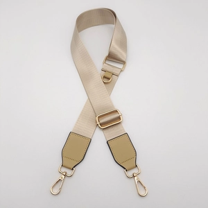 Close-up of champagne gold nylon bag strap with shiny gold metal lobster clasps
