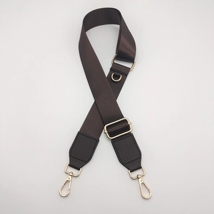 Detail of adjustable coffee nylon bag strap with gold metal D-ring and lobster clasps