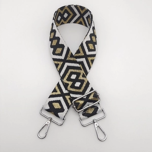Detail of ethnic geometric woven bag strap with silver metal swivel hooks and buckles