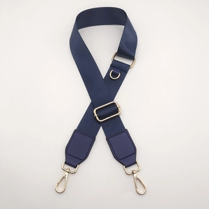 Detail of navy nylon crossbody strap with gold D-ring and swivel carabiner hooks