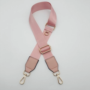 Detail of adjustable pink nylon shoulder strap with gold swivel hooks and D-ring buckle
